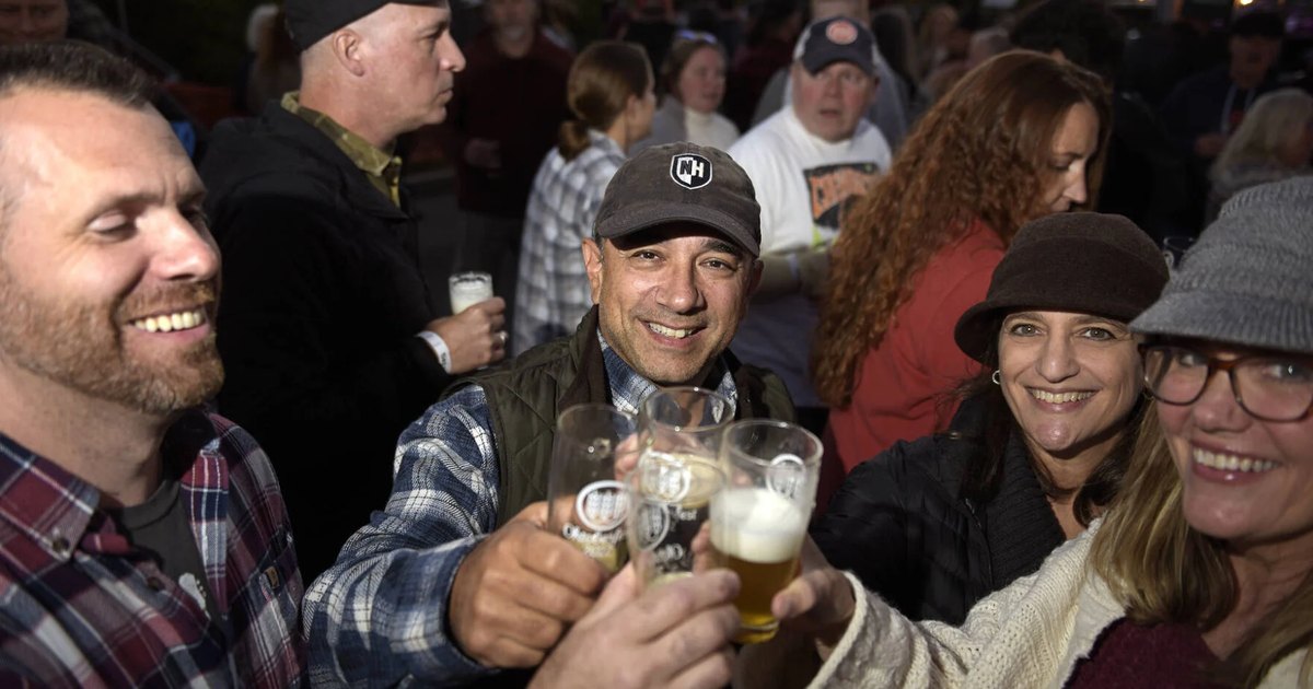 People raising beer glasses at an Oktoberfest gathering