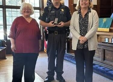 Three people standing together indoors